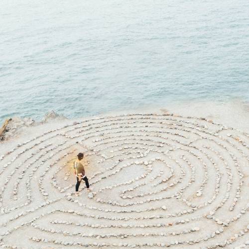 Femme marchant dans un labyrinthe au bord d'une falaise