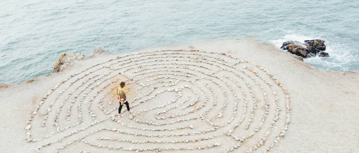 Femme marchant dans un labyrinthe au bord d'une falaise